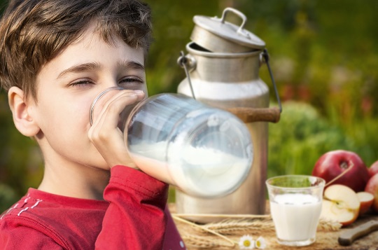 Junge trinkt frische Milch im Freien